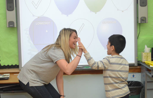 teacher congratulating student with high five