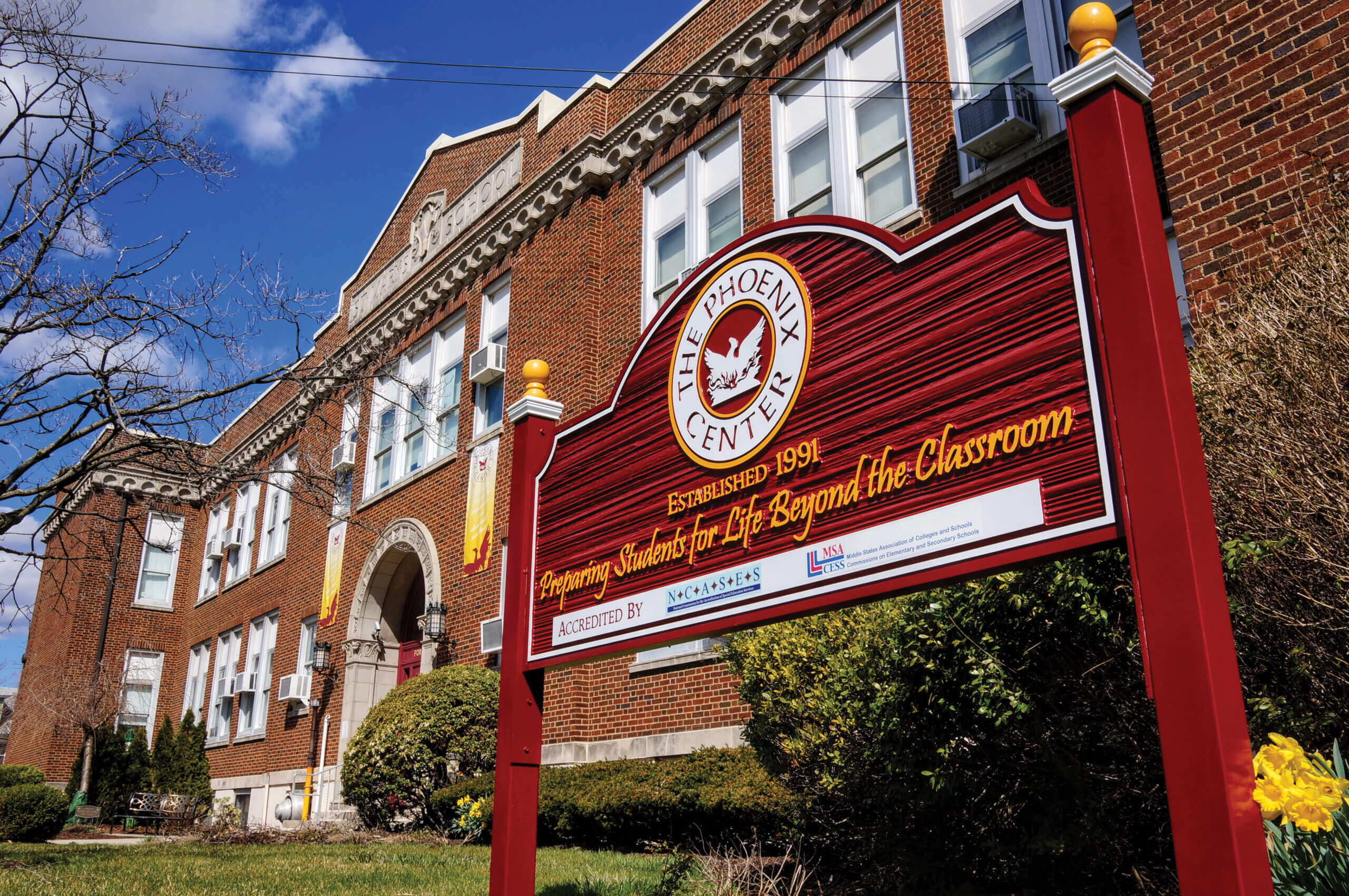 The Phoenix Center school sign with school building in background