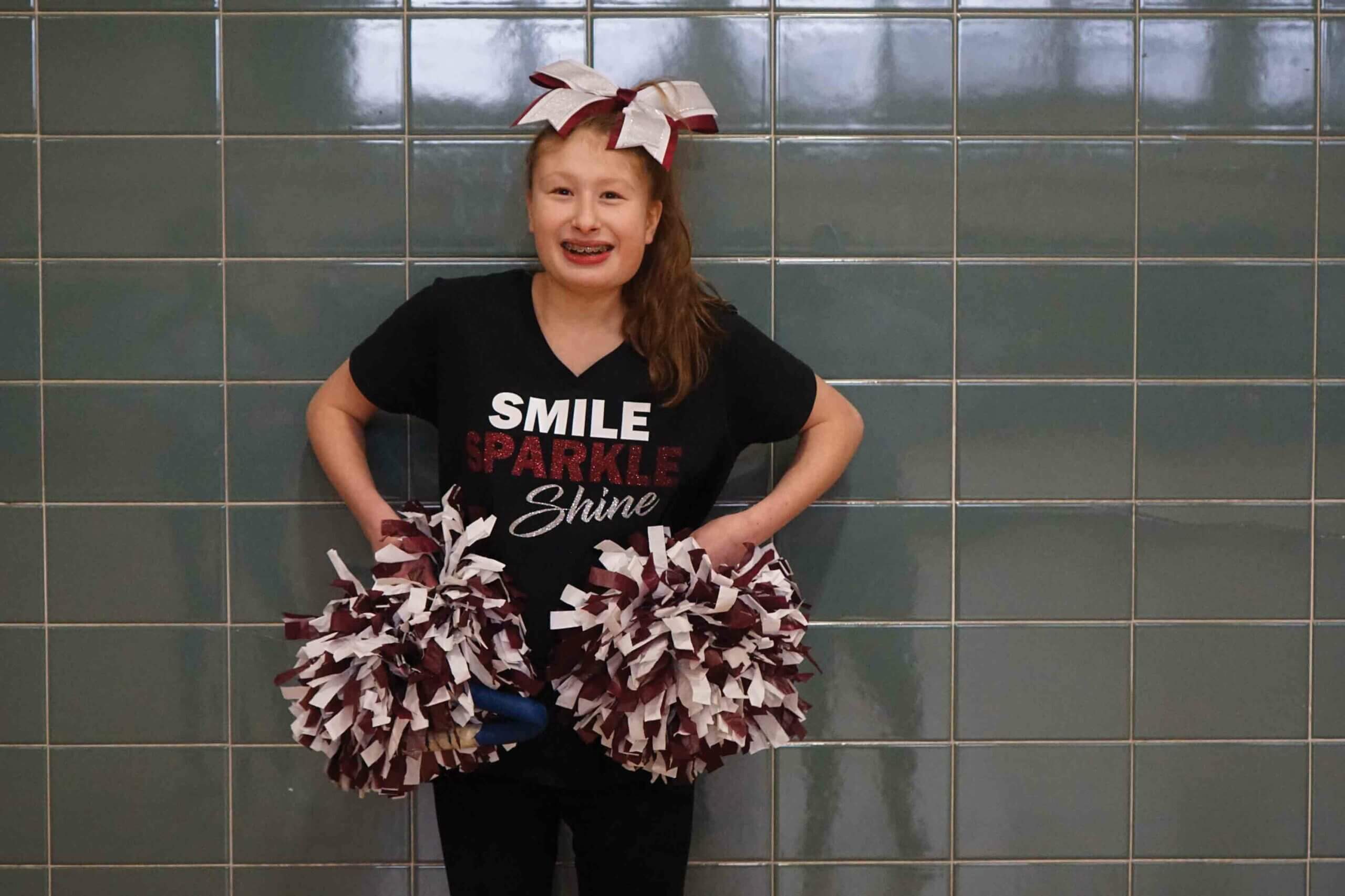 Girl cheerleader holding pom-poms