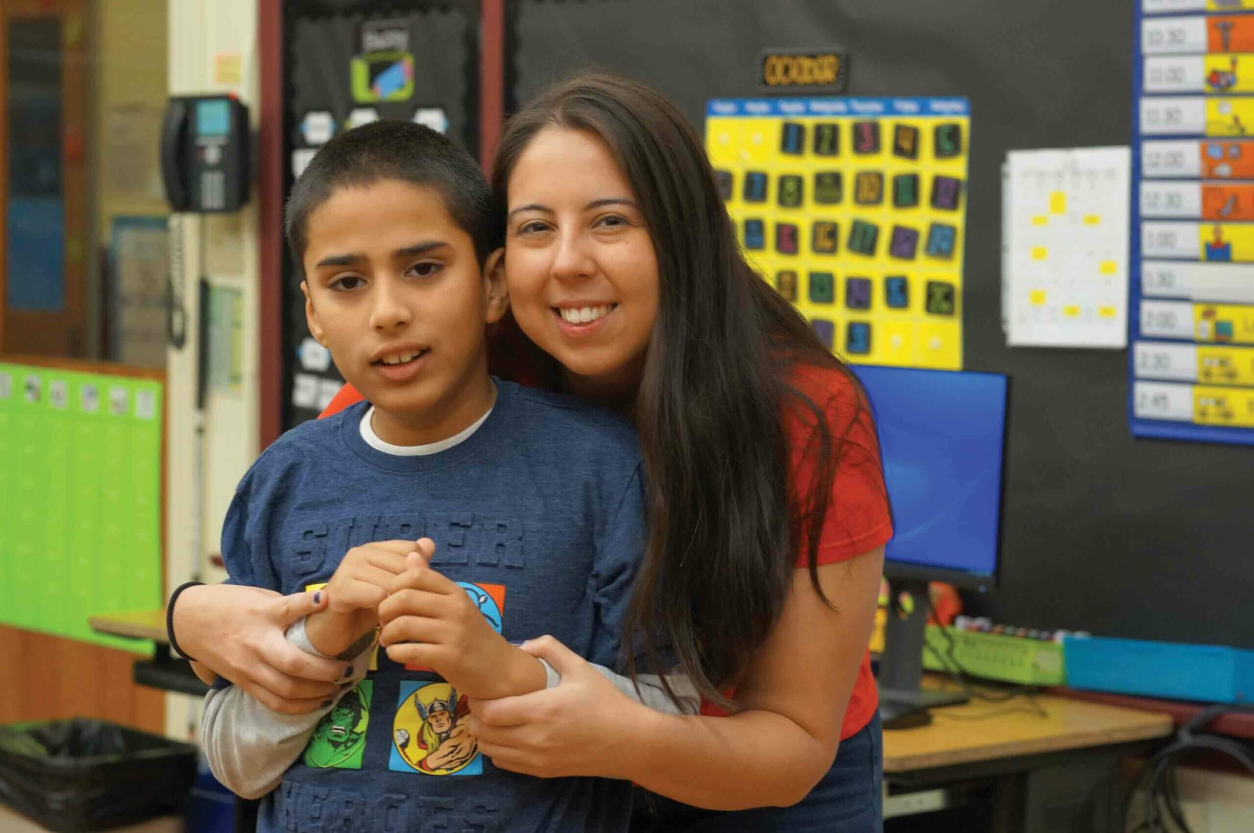 Teacher with arms around student